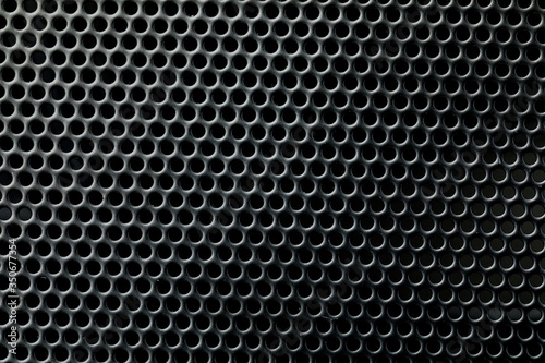 Metallic background with perforation of round holes. Black metal texture with round holes