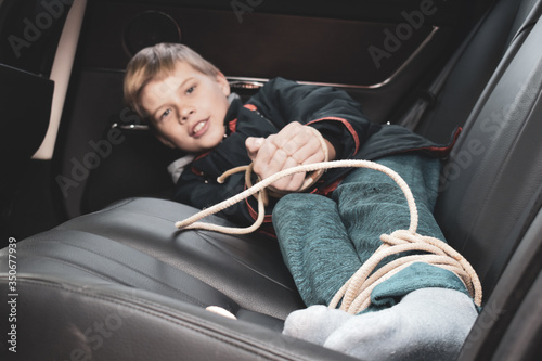 Fotografija the captive child in the car. Illegal theft and ransom of a child