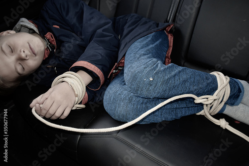 Fototapet the captive child in the car. Illegal theft and ransom of a child