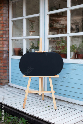 Canvas Print Empty Wooden easel on street