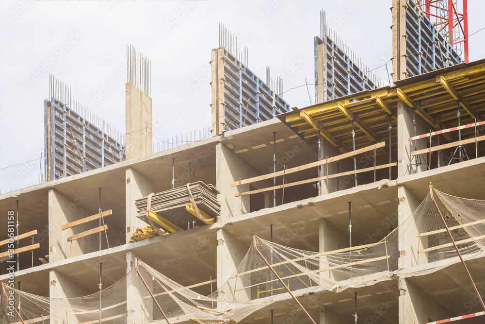 Scaffolding has been installed. Outdoors. Construction of a new residential complex for young families. Concept business, real estate, mortgage. Sunny clear day.