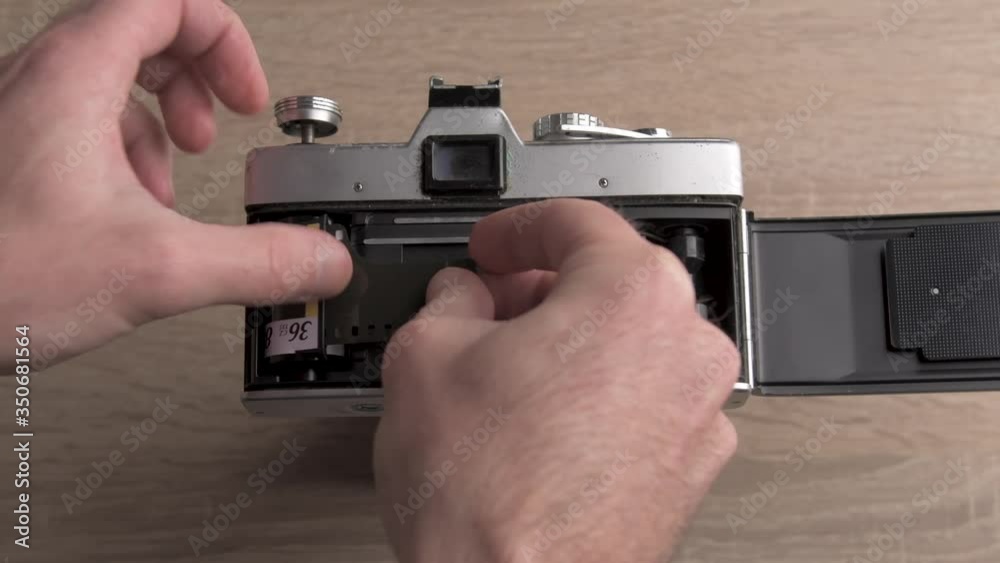 Educational video about analog photography. Putting manually a roll of film into a vintage retro camera.