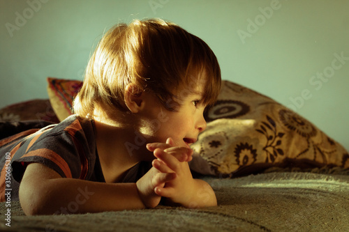 Niño rubio sindrome down, mira picaro a la derecha sorriente photo