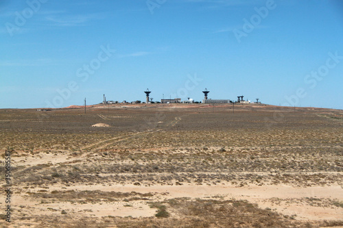 There is a base in the desert. A military or space base far from the city. Desert terrain. The base is under guard. photo