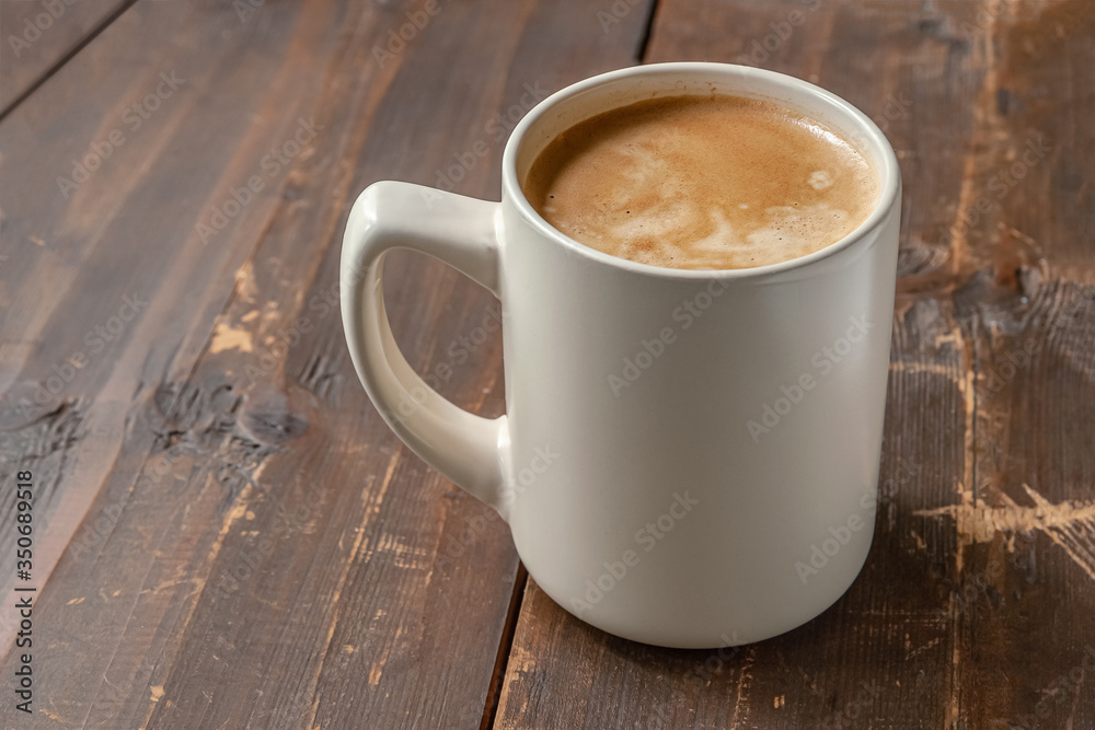 a mug of freshly brewed aromatic coffee on a wooden table a mug of freshly brewed aromatic coffee on a wooden table