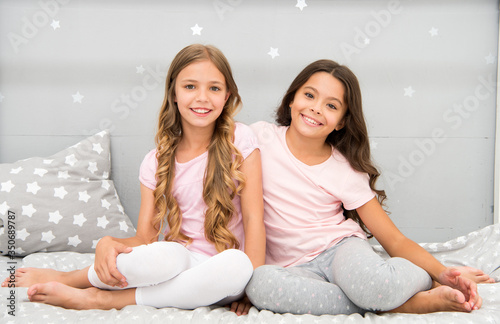 Happy morning. Children in pajamas. Stay at home. Pajamas all day. Cute cozy bedroom for small girls. Sisters having fun bedroom interior. Childhood concept. Bedroom place relax and enjoy rest photo