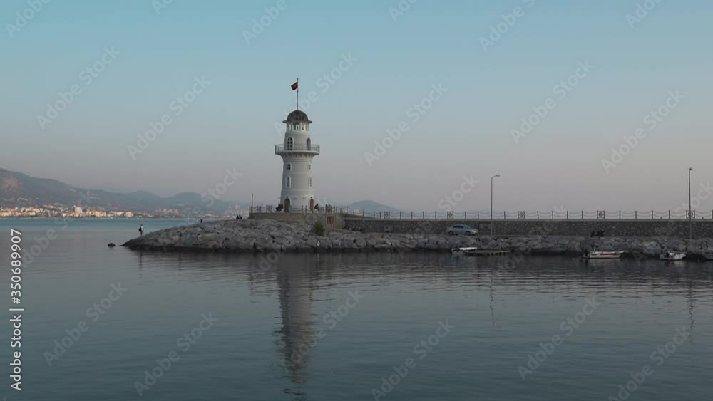 White lighthouse at sunset sky background and sea Bay. White lighthouse at sunset sky background and sea Bay.