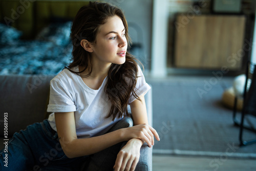 Free Download Beauty young woman sitting on sofa at home - GFXLoad