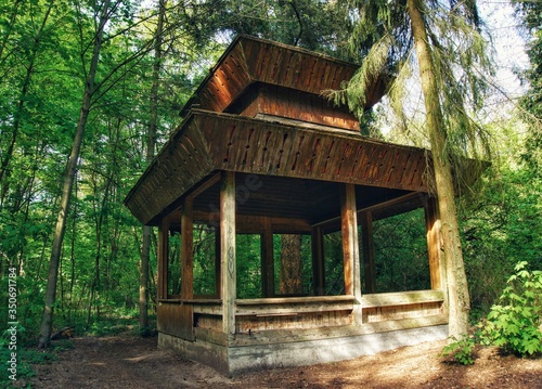 Idyllic view of a wooden pagoda in the forest near the Dammsmühle castle. The forest hut is very old.