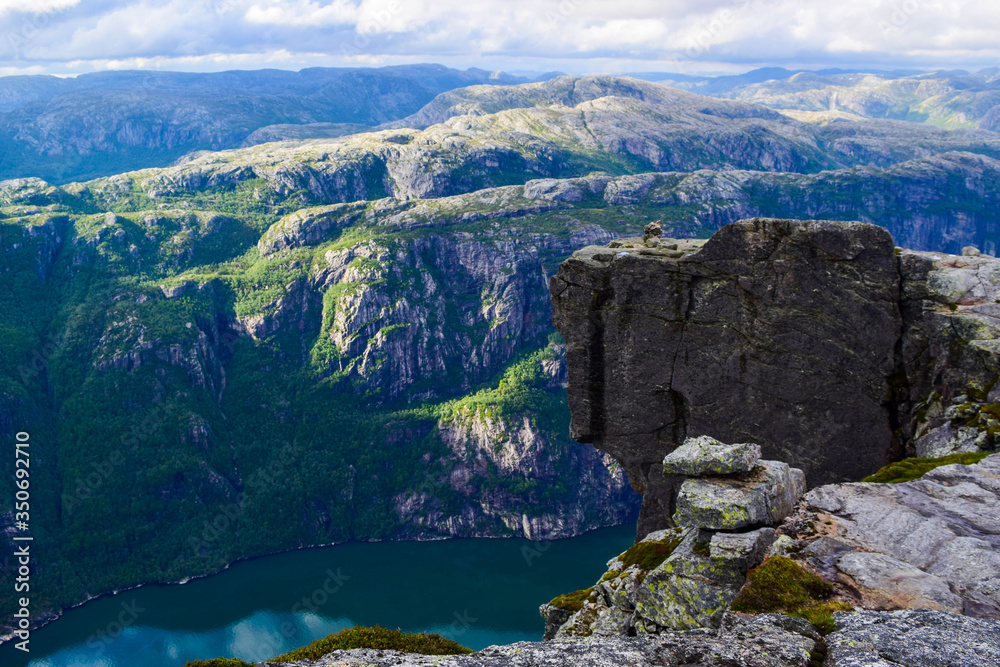 Wonderful mountain landscape of Lysefjorden with clouds reflected in blue water. View from Kjerag plateau, where not far at an altitude of 984 meters stuck between two rocks of Kjeragbolten. Norway.