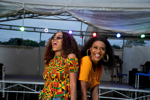 two black girls dancing at a concert held at night