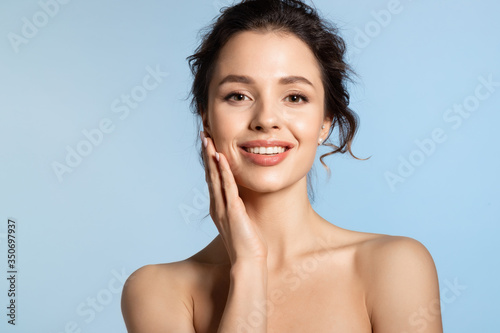 Young woman  enjoy smooth skin and touching cheek with hand.  photo