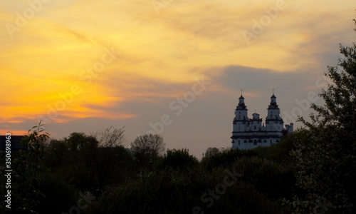 Zachód słońca za kościołem, pomarańczowe niebo, Polska © Mateusz Czarniecki