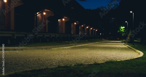 Nocne zdjęcie brukowanej drogi, latarnie i szereg drzwi Białystok, podlaskie, polska, Europa © Mateusz Czarniecki