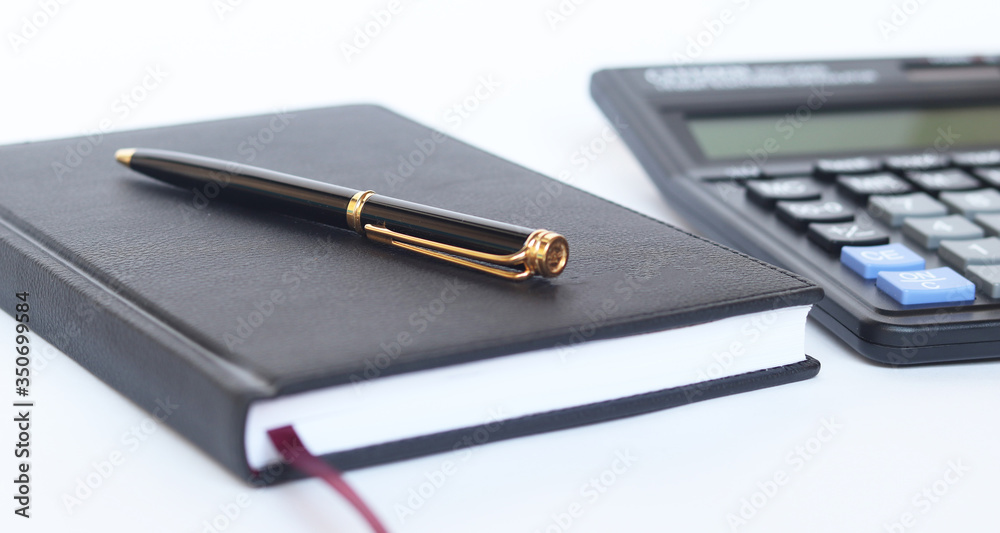 Calculator pen and notebook on white background. Calculator pen and notebook on white background.