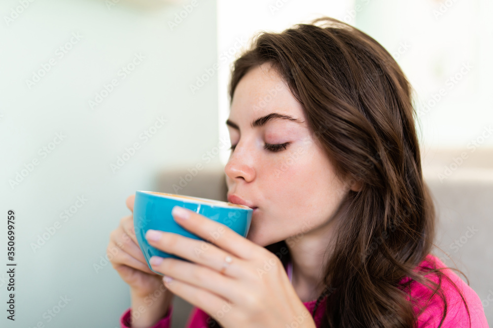 Smiling woman in a good mood with cup of coffee sitting in cafe. Smiling woman in a good mood with cup of coffee sitting in cafe.