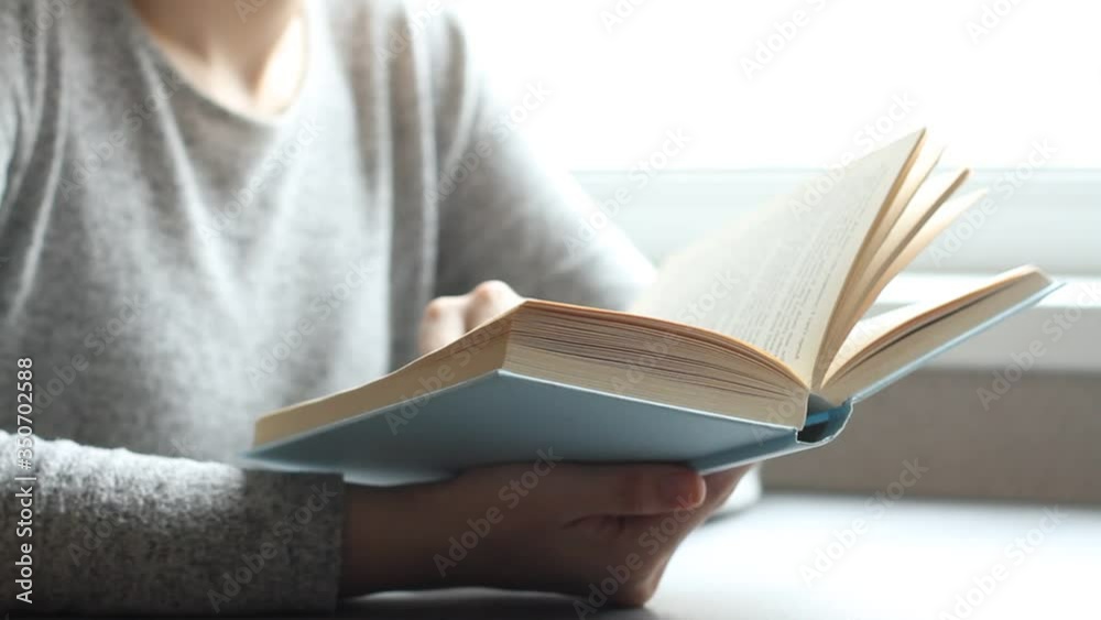 Young woman reading book in living room, turning page, learning, studying, education, read books, stay home concept.
