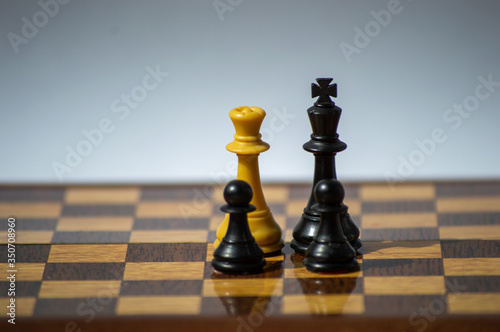 Chess pieces disposed as an interracial family on a chessboard