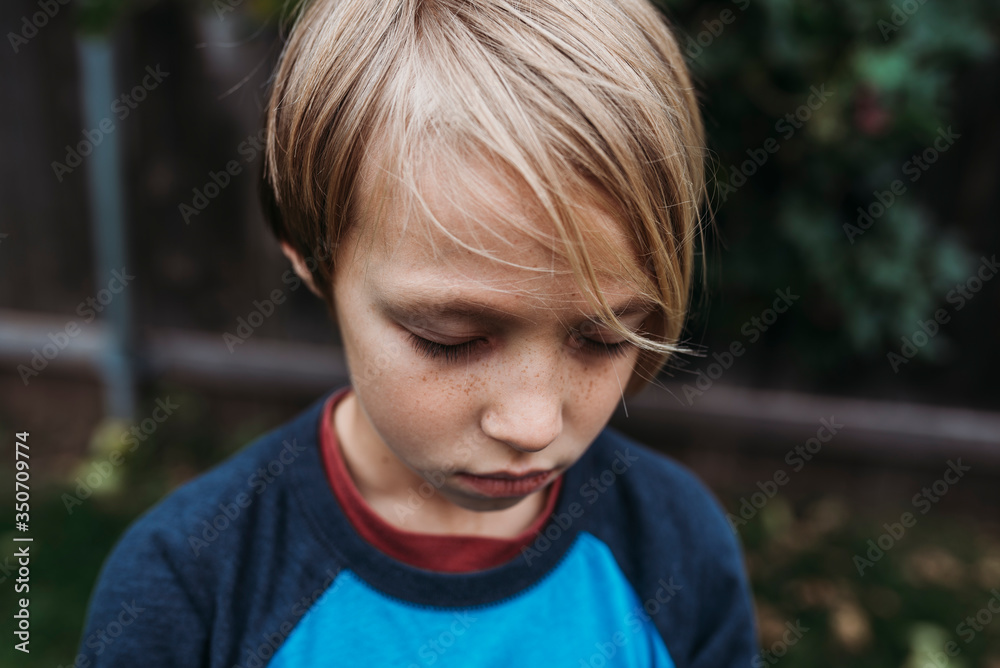 Portrait of boy with eyes closed standing in backyard Portrait of boy with eyes closed standing in backyard