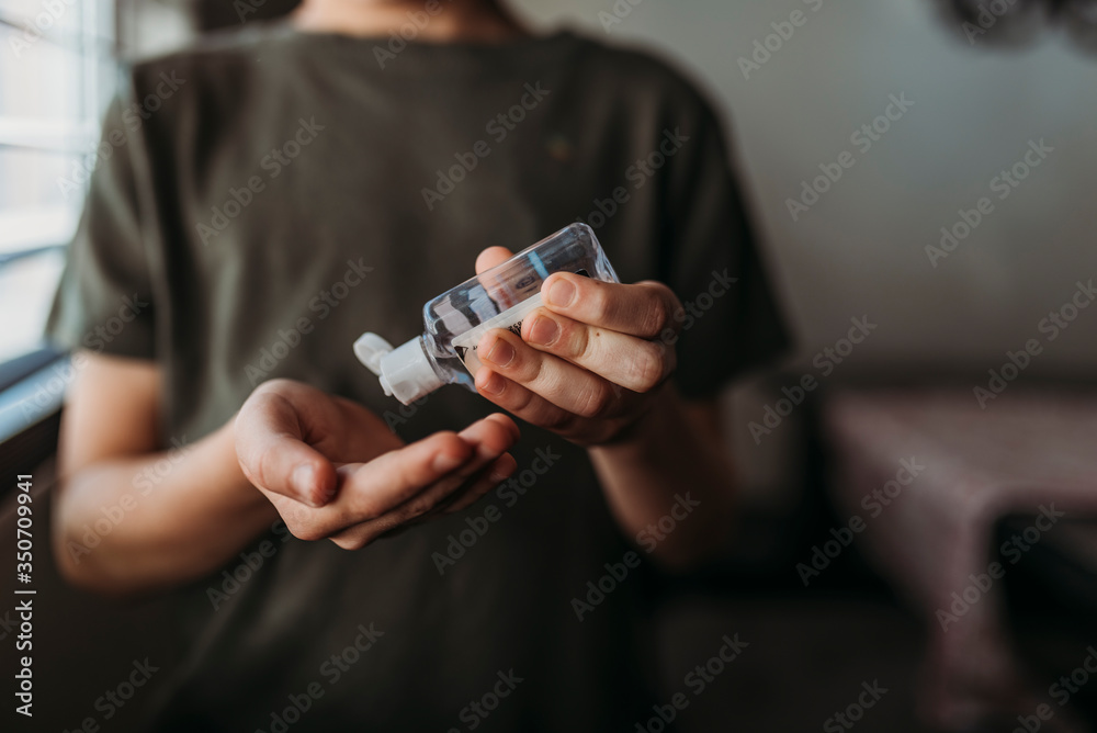 Midsection of boy using hand sanitizer to clean his hands Midsection of boy using hand sanitizer to clean his hands