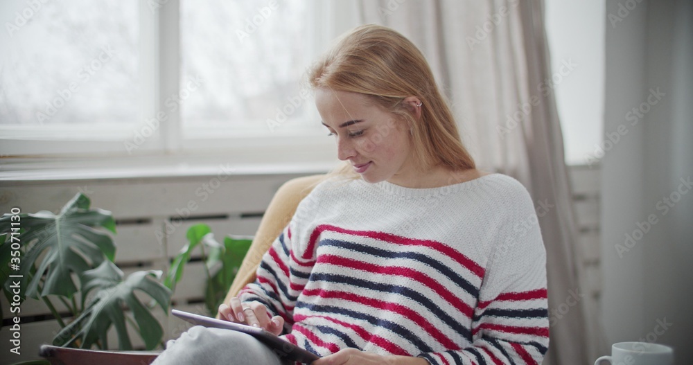 woman relaxing at home holding digital tablet woman relaxing at home holding digital tablet