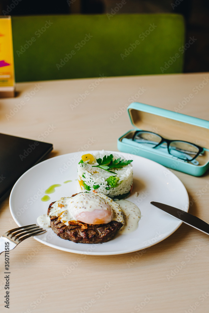 poached egg on steak with rice garnish