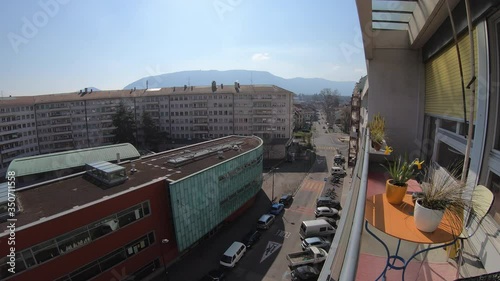 Timelapse street view from balconey, with circulation, table and plants, Mount Saleve in the far, and blue sky, in Carouge, Geneva switzerland. photo