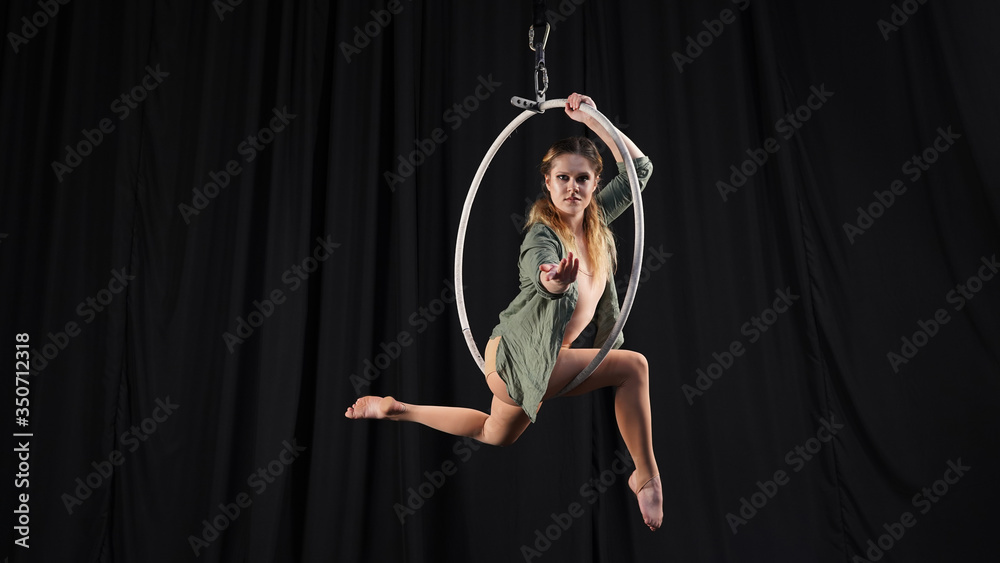 © Artem - Beautiful graceful girl, aerialist. professional circus acrobat on air hoop. performer in ring dancing modern, black background. black curtain backstage drapery, rehearsal, model looks into the lens. © Artem - Beautiful graceful girl, aerialist. professional circus acrobat on air hoop. performer in ring dancing modern, black background. black curtain backstage drapery, rehearsal, model looks into the lens.