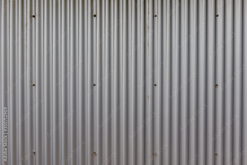 Corrugated zinc metal sheet. Silver grey background vertical wave pattern. Corrugated zinc metal sheet. Silver grey background vertical wave pattern.