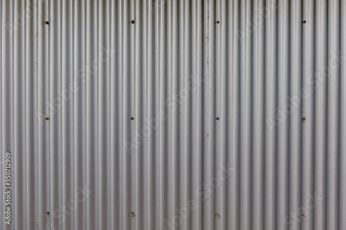 Corrugated zinc metal sheet. Silver grey background vertical wave pattern.