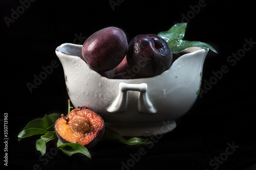 Black apricots in a vase isolated on black