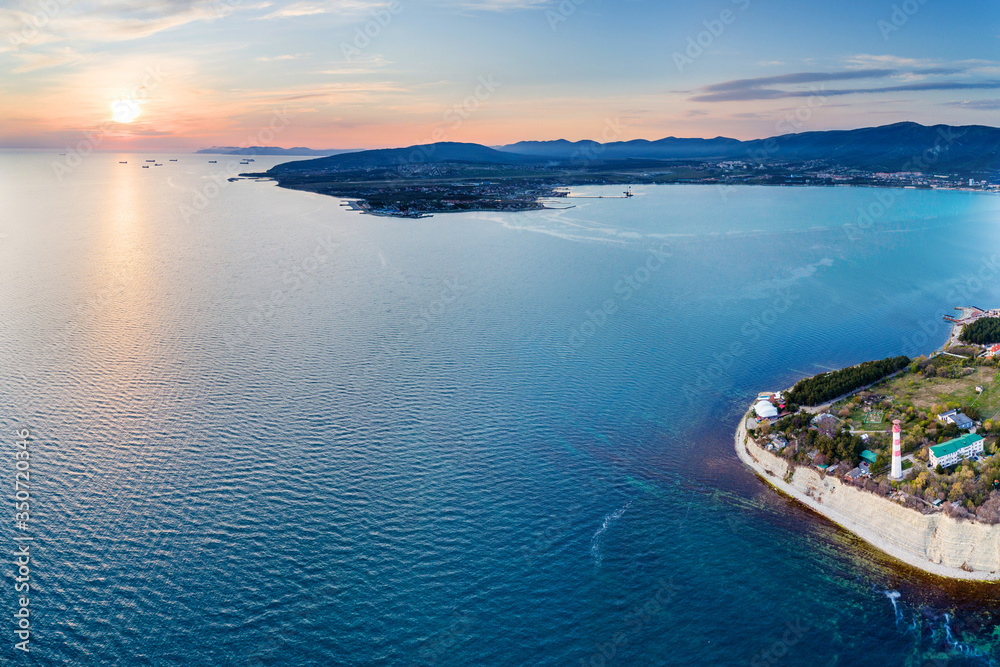 Entrance from a height to the Gelendzhik Bay at sunset in calm, windless weather. In the foreground is a 