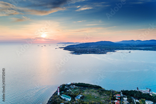 Fototapeta Naklejka Na Ścianę i Meble -  Entrance from a height to the Gelendzhik Bay at sunset in calm, windless weather. In the foreground is a 