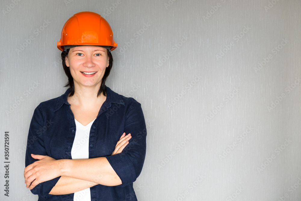 Portrait of smiling female architect against grey background. Successful happy beautiful lady smiling with copy space Portrait of smiling female architect against grey background. Successful happy beautiful lady smiling with copy space