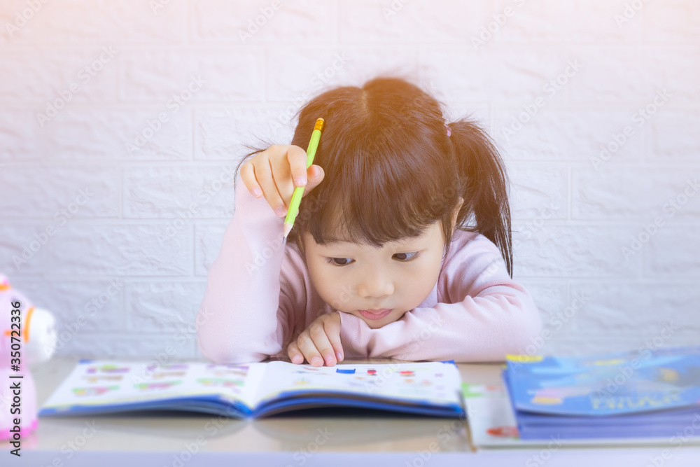 Cute little girl doing homework, reading a book, coloring pages, writing and painting. Children paint. Kids draw. Preschooler with books at home. Preschoolers learn to write and read. Creative toddler Cute little girl doing homework, reading a book, coloring pages, writing and painting. Children paint. Kids draw. Preschooler with books at home. Preschoolers learn to write and read. Creative toddler