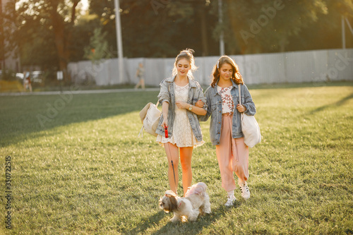 Girls in a park. Friends with a dog.