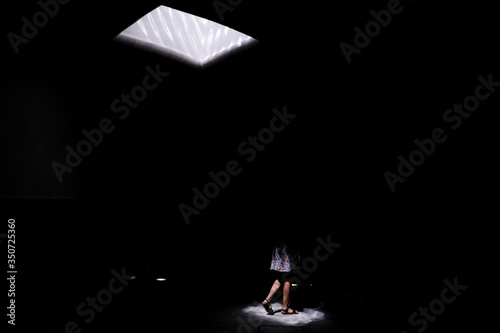 Window in the roof and woman legs in dark environment