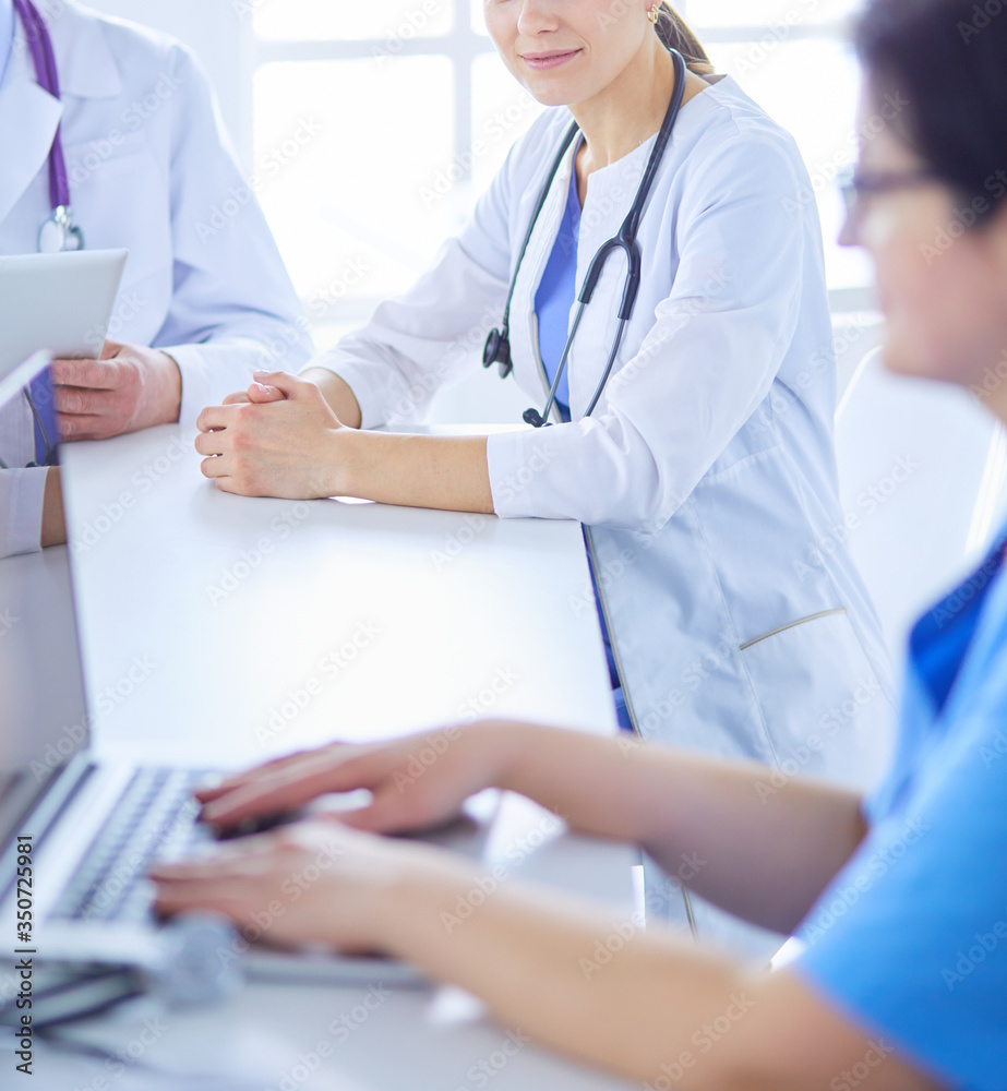 Serious medical team discussing patient's case in a bright office
