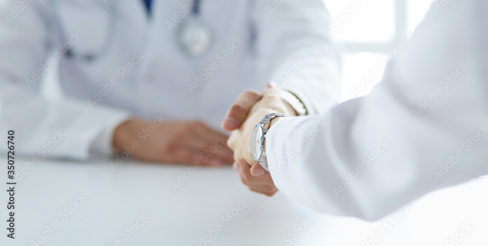 Doctor shaking hands with a male patient in the office Doctor shaking hands with a male patient in the office