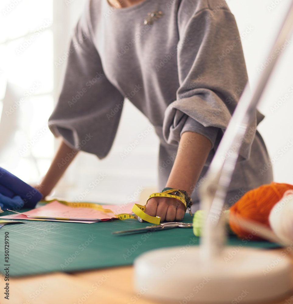 Fashion designer in workshop working on laptop