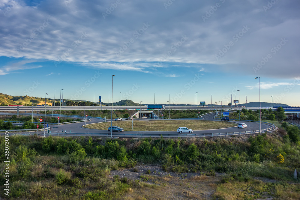 View of a roundabout accessing the A-2 road outside Alcalá de Henares, in the afternoon with little traffic.