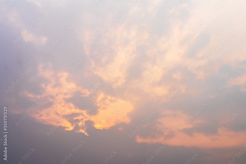 Orange light shining through the overcast clouds. - obrazy, fototapety, plakaty 