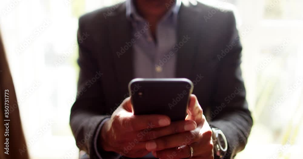4k, young businessman working from home and texting on his mobile phone.