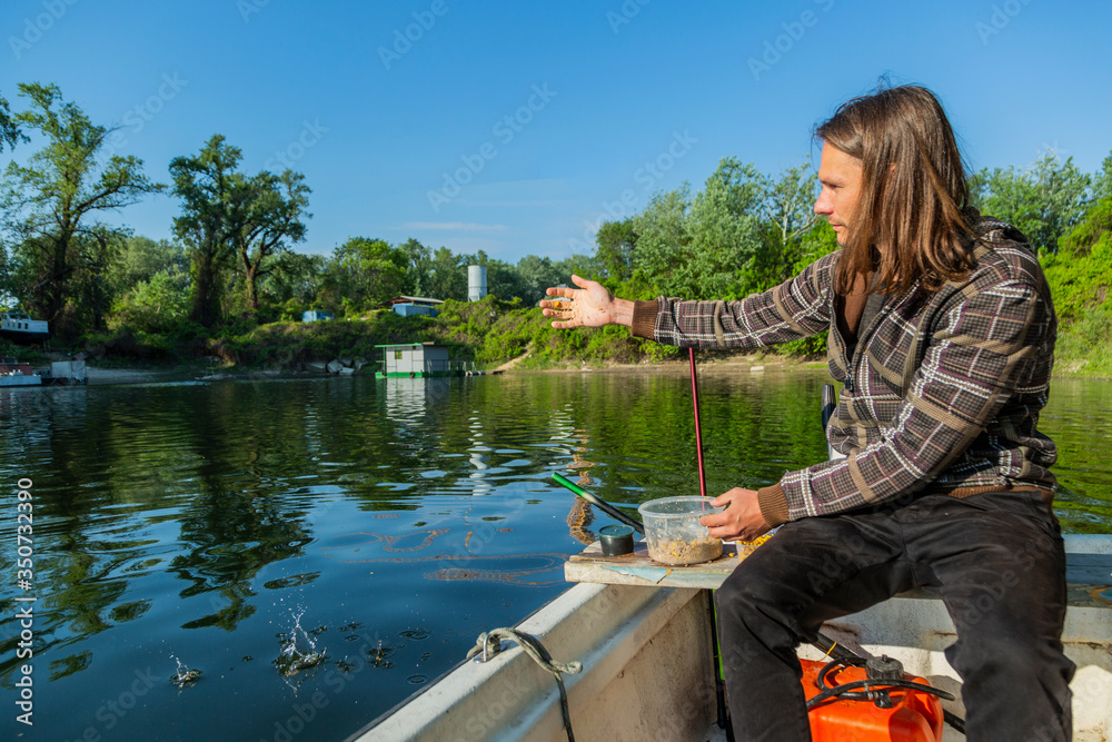 Fototapeta premium Fish feeding from boat in lake corner