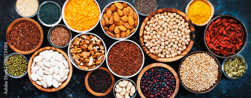 Fototapeta Naklejka Na Ścianę i Meble -  Superfoods, legumes, nuts, seeds and cereals selection in bowls on grey background. Superfood as chia, spirulina, beans, goji berries, quinoa, turmeric, mung bean, buckwheat, lentils, flax seed