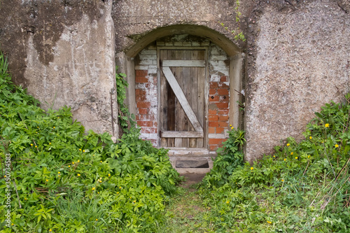 door for entering the storage room for storing vegetables and canned goods. The old basement is in poor condition. © Roman