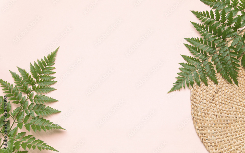 Round wicker stand and palm leaves on pink background. Flatlay style concept with text place. - obrazy, fototapety, plakaty 