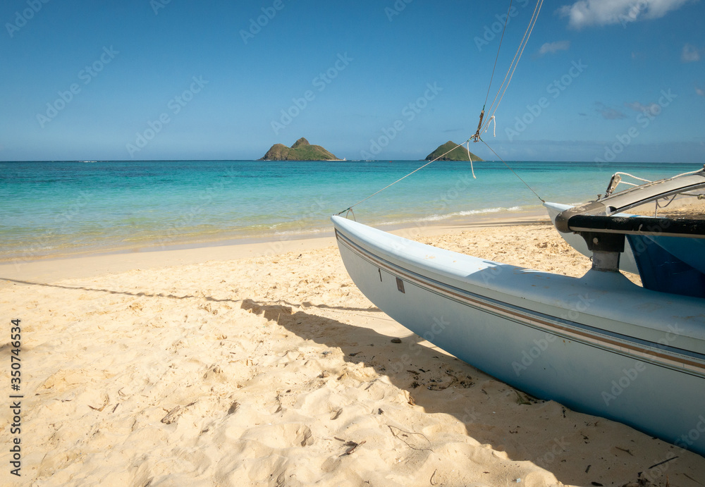 Sailing boat parked on tropical sandy beach with azure waters, shot at Kailua Beach, Oahu, Hawaii, USA