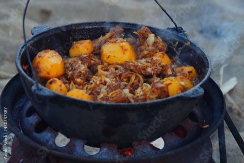 tasty food cooked with smoke on a campfire in nature