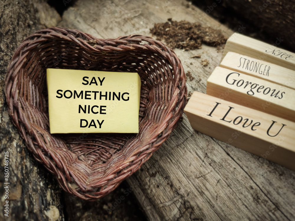motivational and inspirational celebration concept - SAY SOMETHING NICE DAY text on notepaper inside heart shaped basket in vintage background